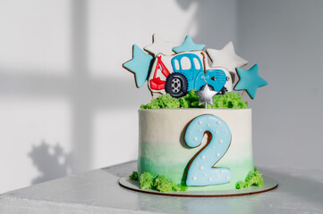Cake with a figure tractor and stars decorated green, blue decor for a boy. Birthday cake for 2...