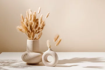 Fotobehang Scandinavisch Stylish ceramic vase set on the table with dried lagurus grass bouquet with shadows, light brown wall background. Scandinavian vase on the table with copy space, minimal aesthetic interior decoration  © Natureveryday