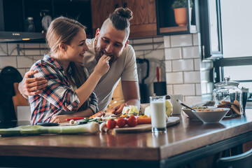 Young couple preparing a meal in their kitchen.	
