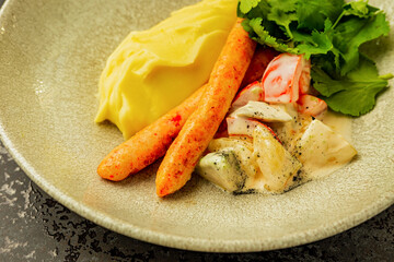 Close-up of homemade sausages with mashed potatoes and vegetable salad