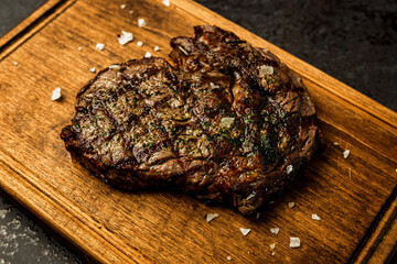 Boneless ribeye steak served on a wooden board in a restaurant - 591465629