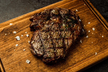 Boneless ribeye steak served on a wooden board in a restaurant - 591465845