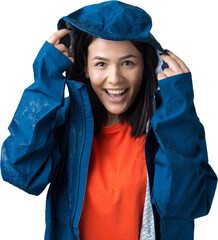 Portrait of a smiling girl dressed in blue raincoat in drops posing with hood on grey background in a studio.