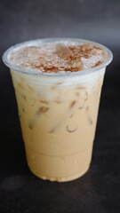 Iced coffee in plastic disposable togo cup isolated on black background.