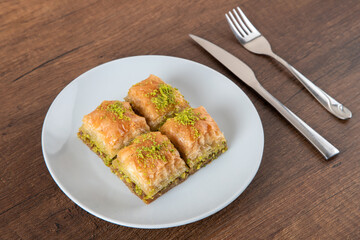 Turkish baklava with pistachio in plate.A plate baklava on wooden background,top view
