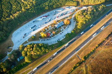 Aerial view of big rest area near busy american freeway with fast moving cars and trucks....