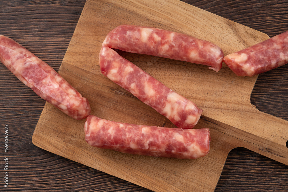 Wall mural raw taiwanese sausage in garlic flavor in a plate on wooden table background.