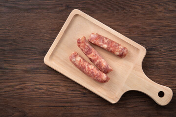 Raw Taiwanese sausage in garlic flavor in a plate on wooden table background.