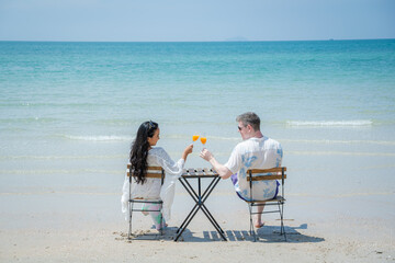 Couple sitting on chair at sea beach,Summer vacation.