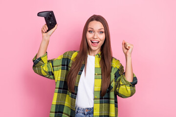 Photo of young funny girl raise fists up hooray addicted professional cyber gamer hold joystick celebrate victory isolated on pink color background