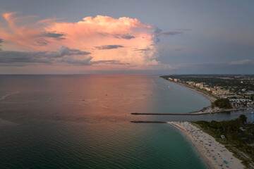 Aerial view of Nokomis beach and South and North Jetty in Sarasota County, USA. Many people enjoing vacation time swimming in gulf water and relaxing on warm Florida sun at sunset