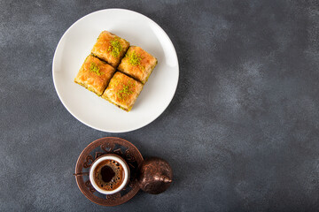 Traditional pistachio baklava with Turkish coffee on black background,top view