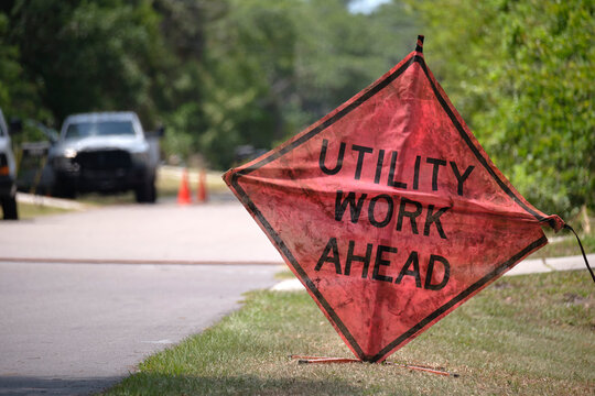 Road work ahead sign on street site as warning to cars about construction and utility works