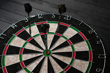 Three darts hit the dartboard. Lucky - one of the darts hits the bull's eye. The concept of winning...