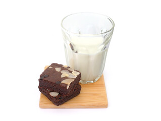 Brownies and milk glass on isolated white background. Chocolate brownie with sliced almond nuts toppings. Chocolate Brownie pieces. selective focus.