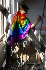 Sadness, pain and loneliness. Young attractive guy with a gay flag.	Sad man.