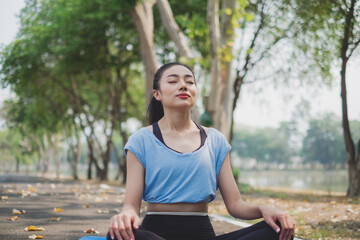 An Asian female doing yoga in the morning, Concept of meditation, relaxation, calmness,...