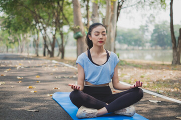 An Asian female doing yoga in the morning, Concept of meditation, relaxation, calmness, concentration, comfort, zen, spiritual warm up, solitude healing and consciousness and serenity. Copy space.