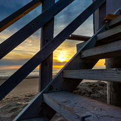 zachodzące słońce zza schodów na plaży