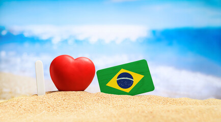 Flag of Brazil on the beach with a red heart. vacation and travel concept.