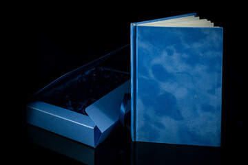 Best gift for men. Man gift concept. Blue notebook with navy blue gift box on black background. Copy space text. wedding, birthday and special occasion gift concept. Copy space for text.