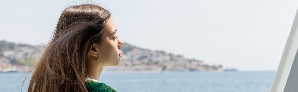 Side View Of Young Brunette Woman Looking At Blurred Sea And Princess Islands In Turkey, Banner.