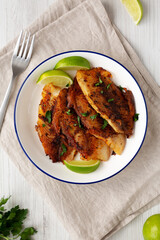 Homemade Pan Seared Tilapia on a Plate, top view. Flat lay, overhead, from above.