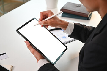 Cropped shot of millennial man worker using stylus pen pointing on digital tablet. Blank screen for graphic display montage