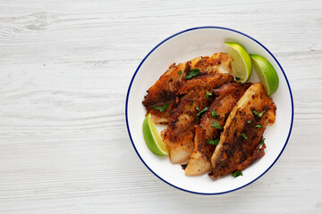 Homemade Pan Seared Tilapia on a Plate, top view. Flat lay, overhead, from above. Copy space.
