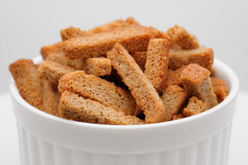 Crispy toasted bread croutons. A pile of hard rusks from dark dry bread close up. Snack for beer. Rye crackers. Snacks rye crackers in a strip. Crouton or brown roasted tostes. 