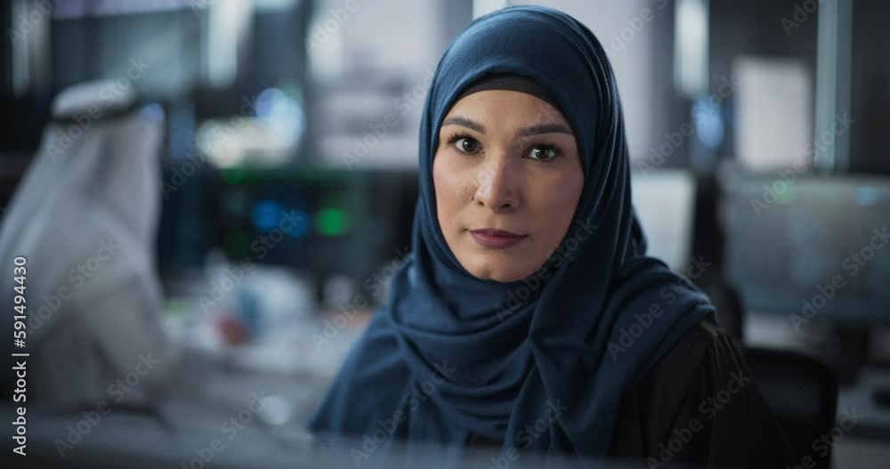 Aufkleber portrait of a middle eastern female using desktop computer, looking at camera and smiling. empowered
