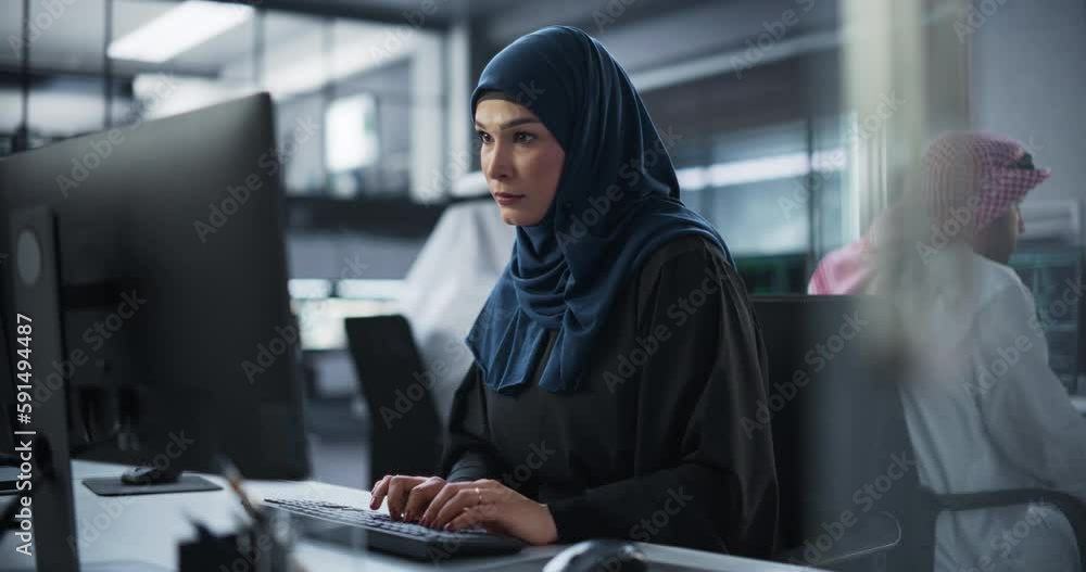Aufkleber Young Arab Female Artificial Intelligence Engineer Working on Computer in a Technological Office. Young Middle Eastern Specialist Writing Software Code for an Innovative Big Data Blockchain Project