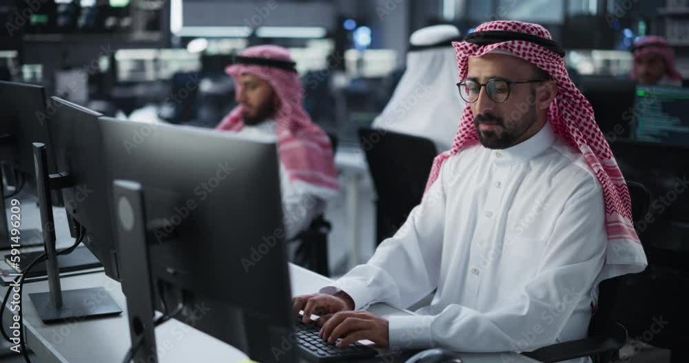 Poster Portrait of a Smart Focused Middle Eastern Programmer Working on Computer in a Technological Corporate Office. Young Gulf Man Developing Software for Generative AI Project