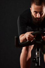 Portrait of a man on an exercise bike in the gym, a man with a beard and glasses on an exercise...