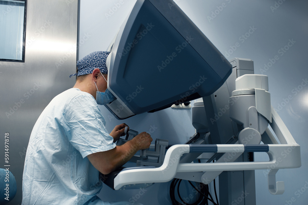 Poster the surgeon is at the computer robot in a special control module, the medical robot is under the con