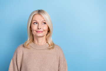 Portrait of pretty minded lady look interested empty space contemplate isolated on blue color...