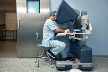 The surgeon is at the computer robot in a special control module, the medical robot is under the...