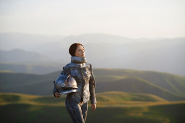 Contemplative woman with space helmet standing on landscape