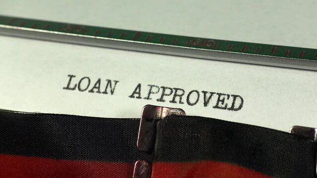 Typing Loan Approved on an old manual typewriter. Authorisation for financial credit and borrowing.