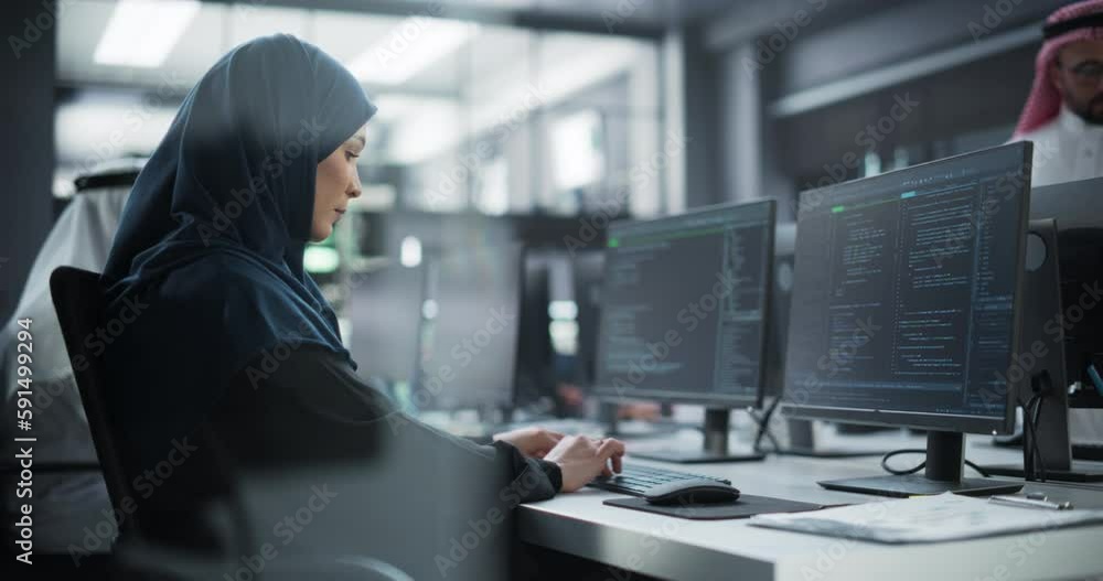 Poster Arab Female Artificial Intelligence Engineer Working on Desktop Computer in a Startup Office. Young Middle Eastern Specialist Writing Software Code for an Innovative Big Data Blockchain Project