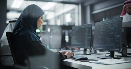Arab Female Artificial Intelligence Engineer Working on Desktop Computer in a Startup Office. Young Middle Eastern Specialist Writing Software Code for an Innovative Big Data Blockchain Project - Powered by Adobe