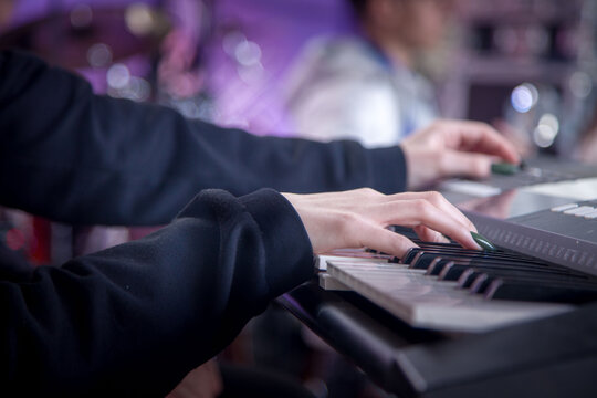 close-up of the hands of a musician playing the synthesizer