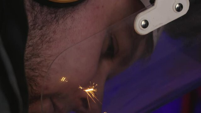 Man wearing a face shield protects himself from hot sparks
