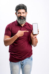 Indian man showing smartphone on white background.