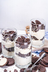 Cream and cookie layered dessert. Homemade oreo trifle, vanilla chocolate cookie layered cheese cake in glass, variation of traditional american breakfast dessert