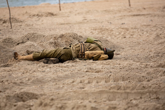 Historical reconstruction. Injured or dead World War II infantry  soldier  on the beach. View from the back.  Hel, Poland