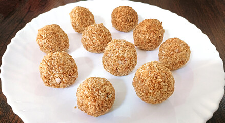 Indian white sesame seeds sweet or tilgul laddu, made up of jaggery and sesame seeds, hand made,...