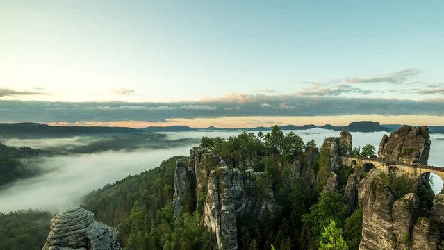 sunrise timelapse with view onto bastei in germany saxon switzerland with fog in the valleys