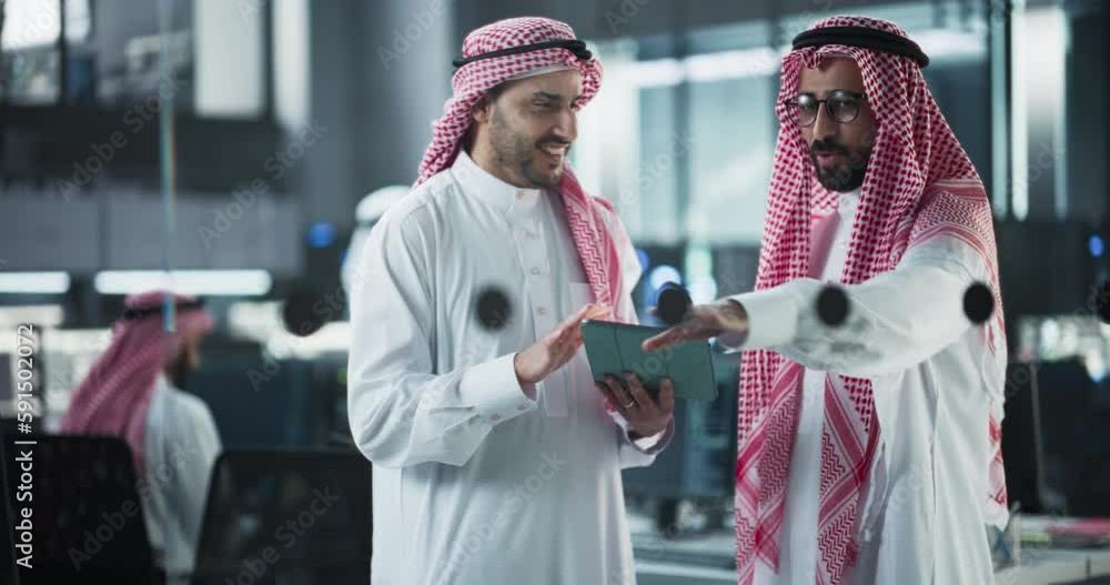 Fototapete Two Multiethnic Arab Colleagues Having a Conversation While Busy Working on a Software Development Project. Engineer Talking with a Middle Eastern Project Manager, Using Tablet Computer in Office