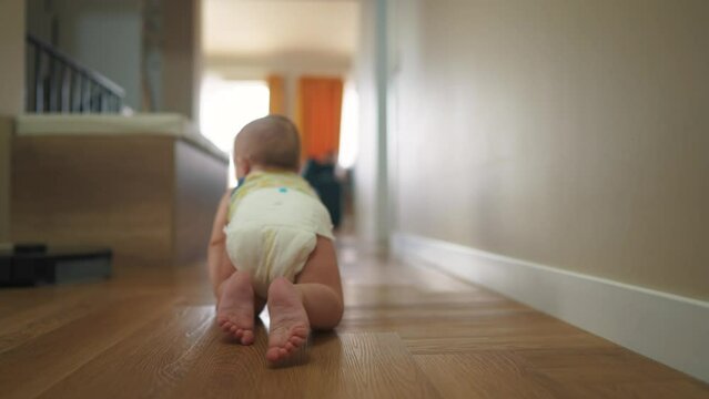 baby newborn crawling on the floor. happy family kindergarten kid concept. First steps, baby crawling view from the back. baby learns to crawl to explore the world dream lifestyle. first steps creeps